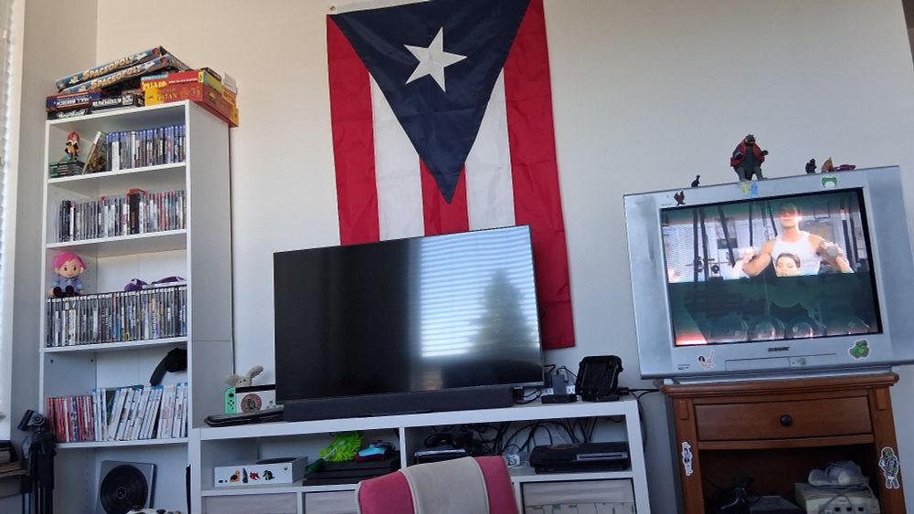 My media wall with two tvs, all my consoles and games but most importantly the Puerto Rican flag behind the tv