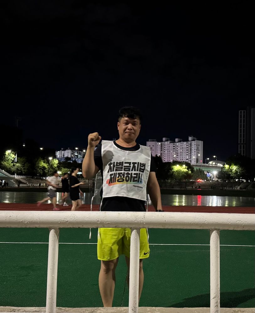 차별금지법 몸자보를 입고 포즈를 취하고 있다.