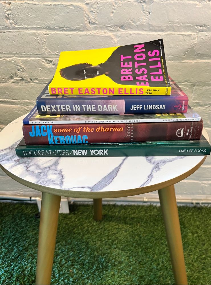 Books on a small table: The Great Cities/New York, Jack Kerouac’s some of the dharma, a Dexter mystery and a Brett Easton Ellis