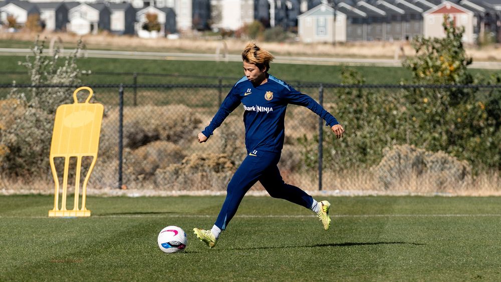 Mina kicking a ball at training