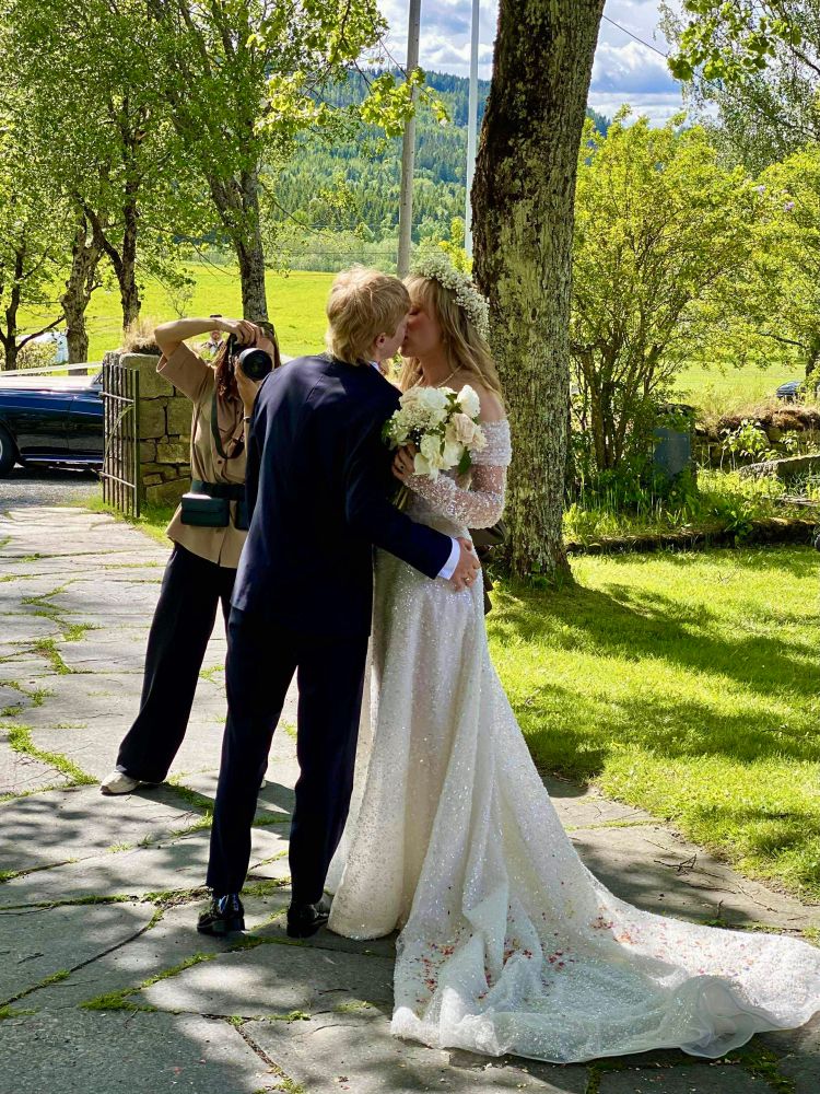 Photo of Magnus and Charlotte outside of the church on their wedding day embracing one another.