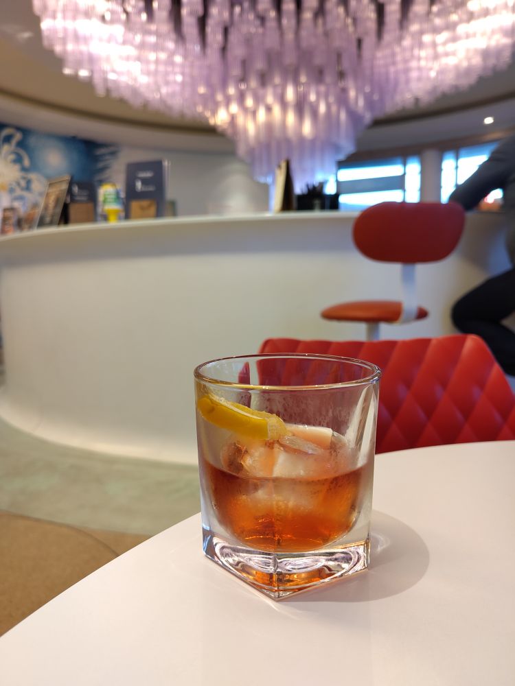 A negro cocktail on a white table against a blurred background of Midland hotel bar, Morecambe