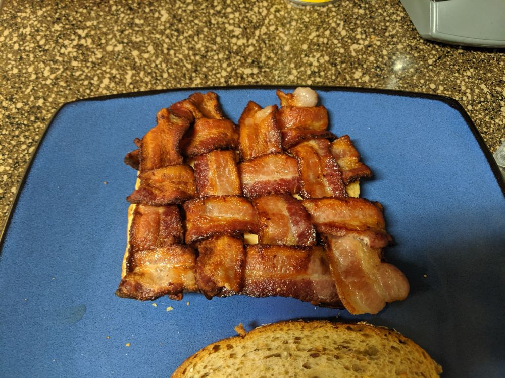 An older photo of my attempt to make a BLT with weaved bacon. It’s on a blue plate. 
