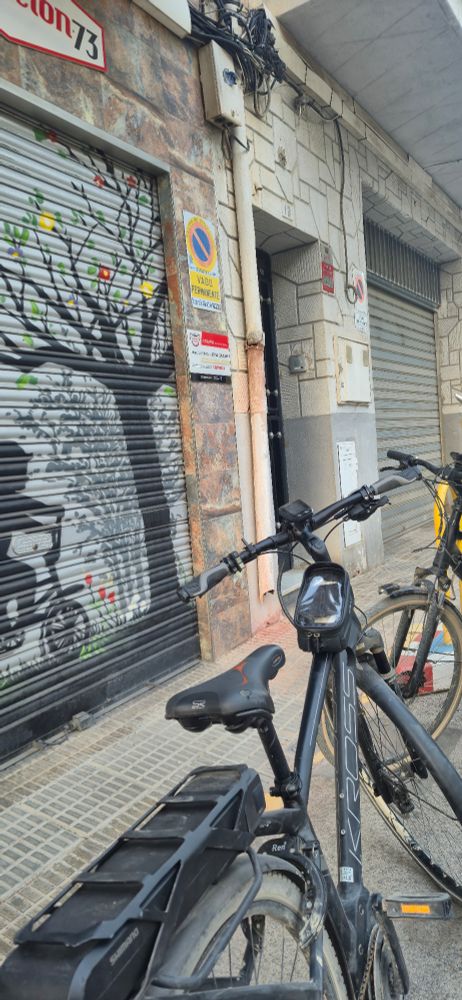Two ebikes in front of a closed bike shop. Maybe it will open. Maybe it won't. 