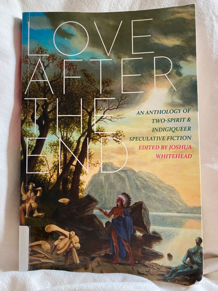 Photograph of the cover of Love After the End: An Anthology of Two-Spirit & Indigiqueer Speculative Fiction. The title is in thin white text, capitalized. Cover art is a painting of trees, beach, figures from a variety of artistic traditions, a lake beach, and a mountain in the background. Rays of light shine from behind clouds.