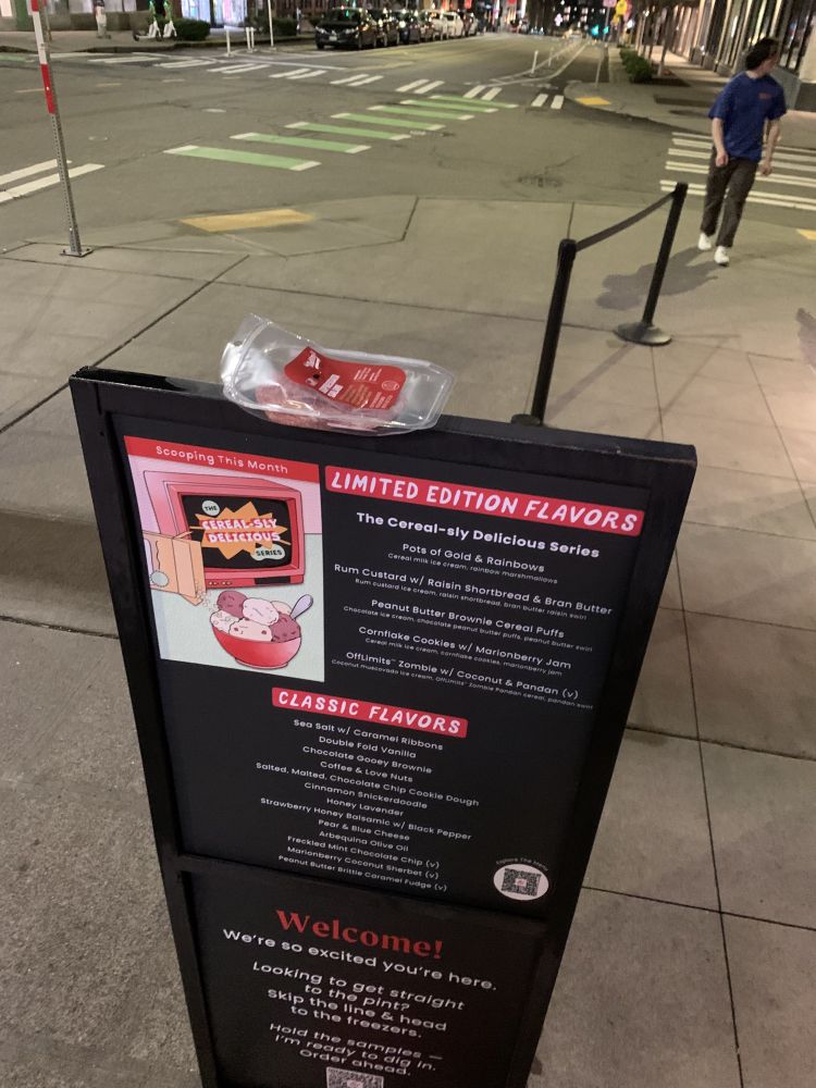a menu sign for Salt & Straw. there is a package of salami on top that is open.