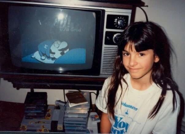 A photograph of a young girl in front of the end screen for Super Mario Bros. 2 (1988).