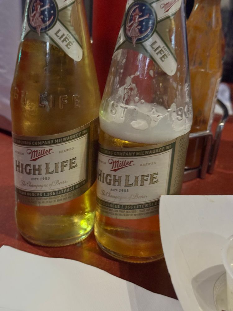 2 bottles of Miller High Life, one slightly less full than the other 