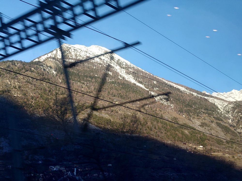 Photo of a snowcapped mountain with blurry catenaries in the foreground