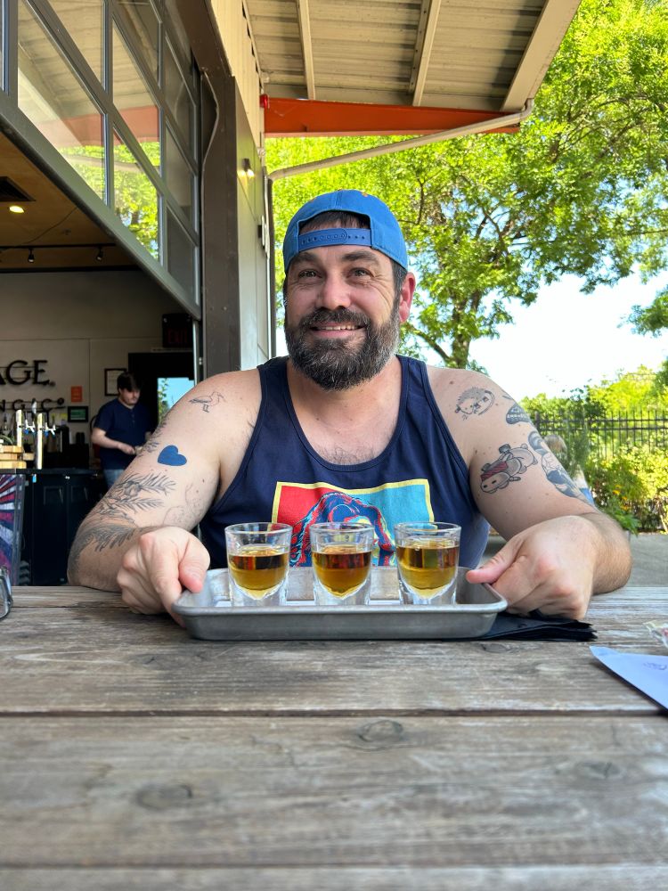 Me holding a flight of whiskeys at a local distillery. 