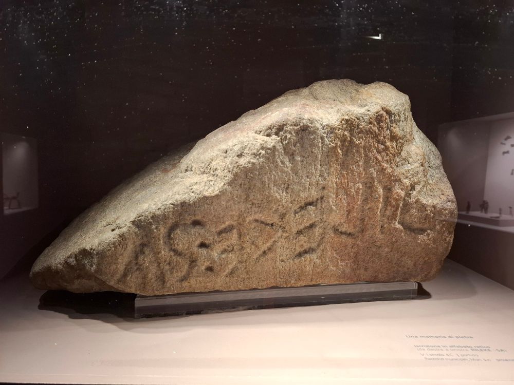 A large rock, with a line of seven inscribed letters