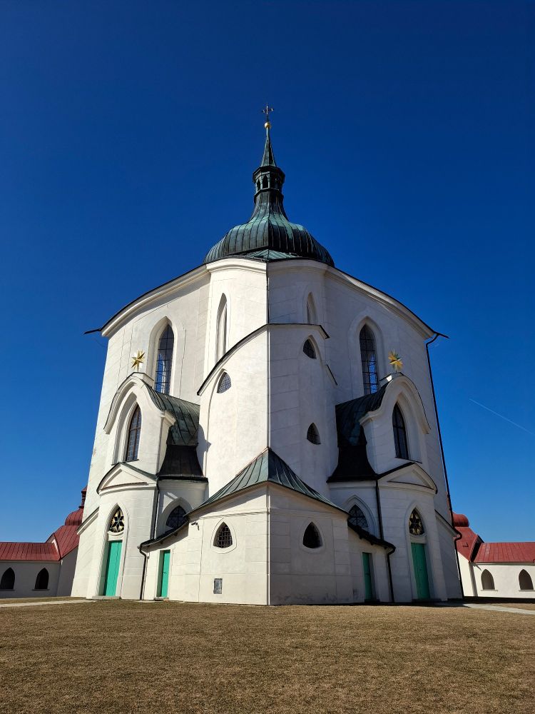 The exterior of a small, white church against a blue sky