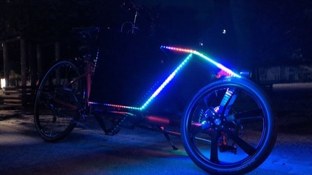 Animiertes Bild eines Lastenrads mit einer Bunten LED Lichtleiste an der Kiste.
Also wenn GIFs funktionieren...