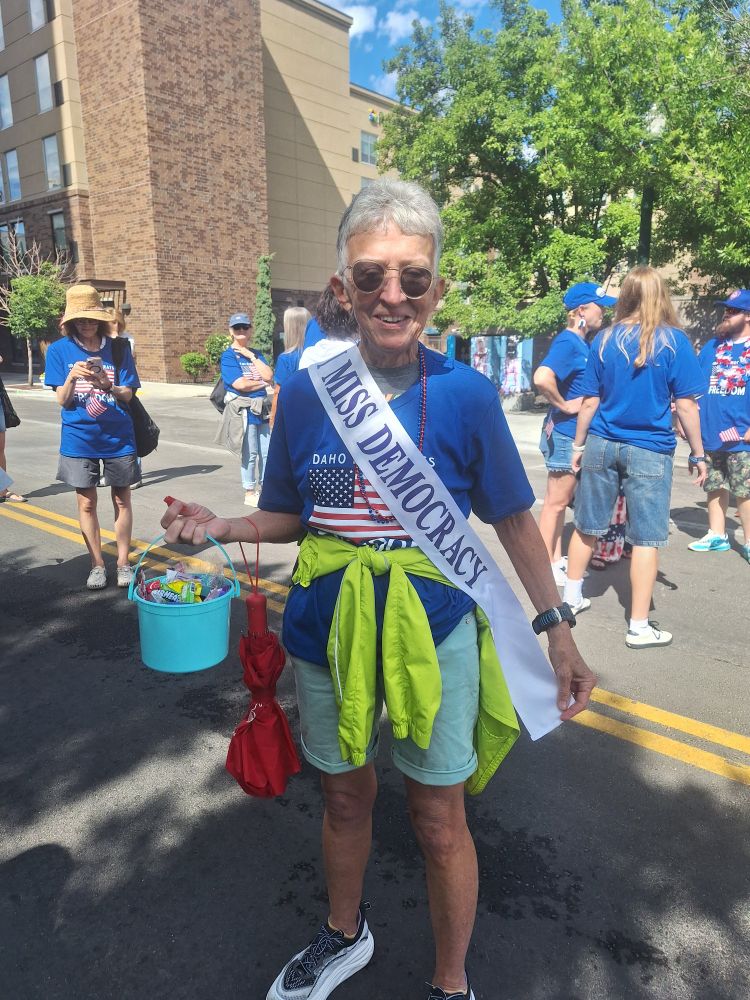 Woman wears "I miss democracy" sash.