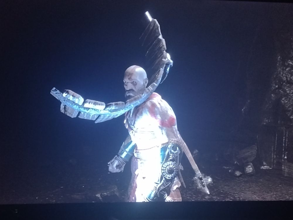 An image of Kratos with a broken barrel stuck on his head and clipping through his neck.