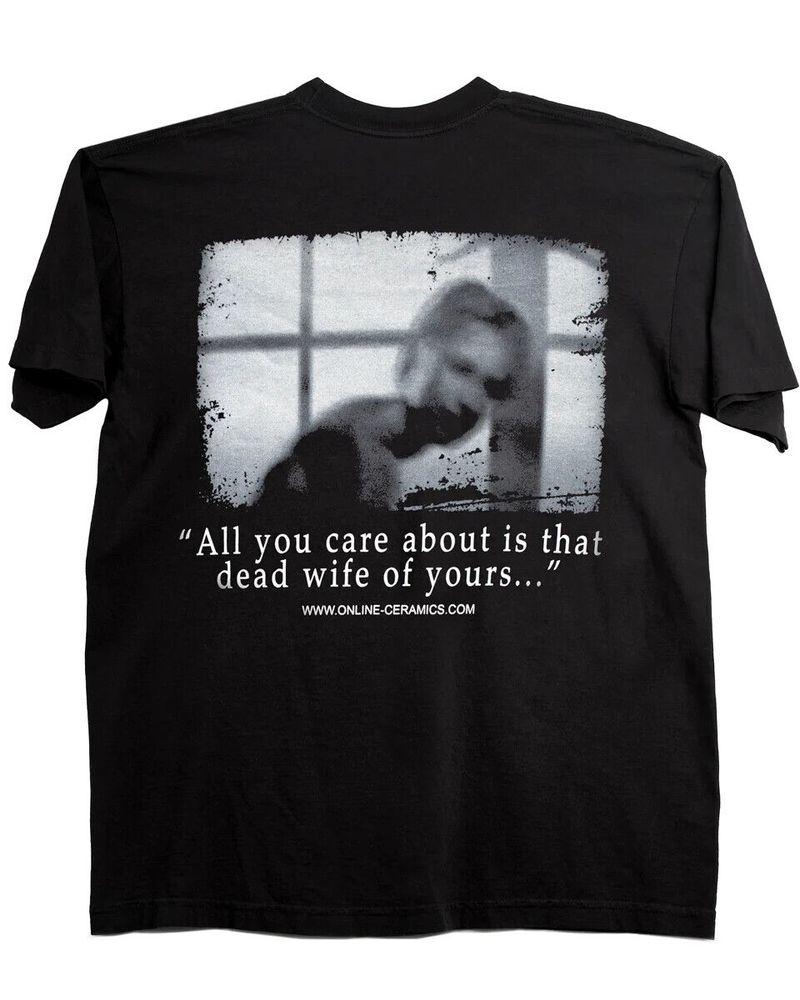 official Online Ceramics and Silent Hill 2 collaboration shirt. A black t shirt with a grey, blurry image of Mary is shown. Beneath it is a quote from Maria, "All you care about is that dead wife of yours..."