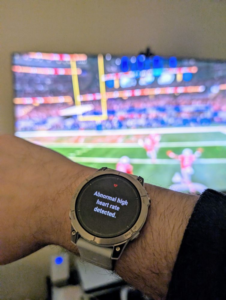 Watch showing "Abnormal high heart rate detected" in front of TV showing OSU / Texas game