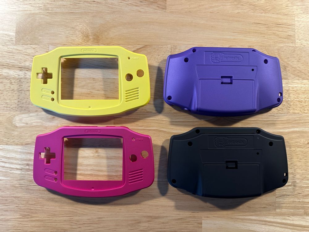 GBA shell parts. Yellow and magenta fronts, purple and black backs. Not pictured: my disappointment at not having one that’s neon green.