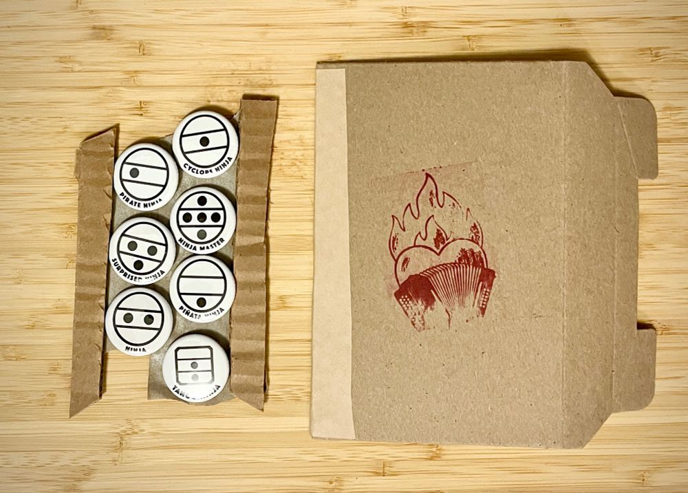 A set of seven round white button badges with accordion register symbols of lines and dots that look a bit like cartoon stick figure ninja faces. 