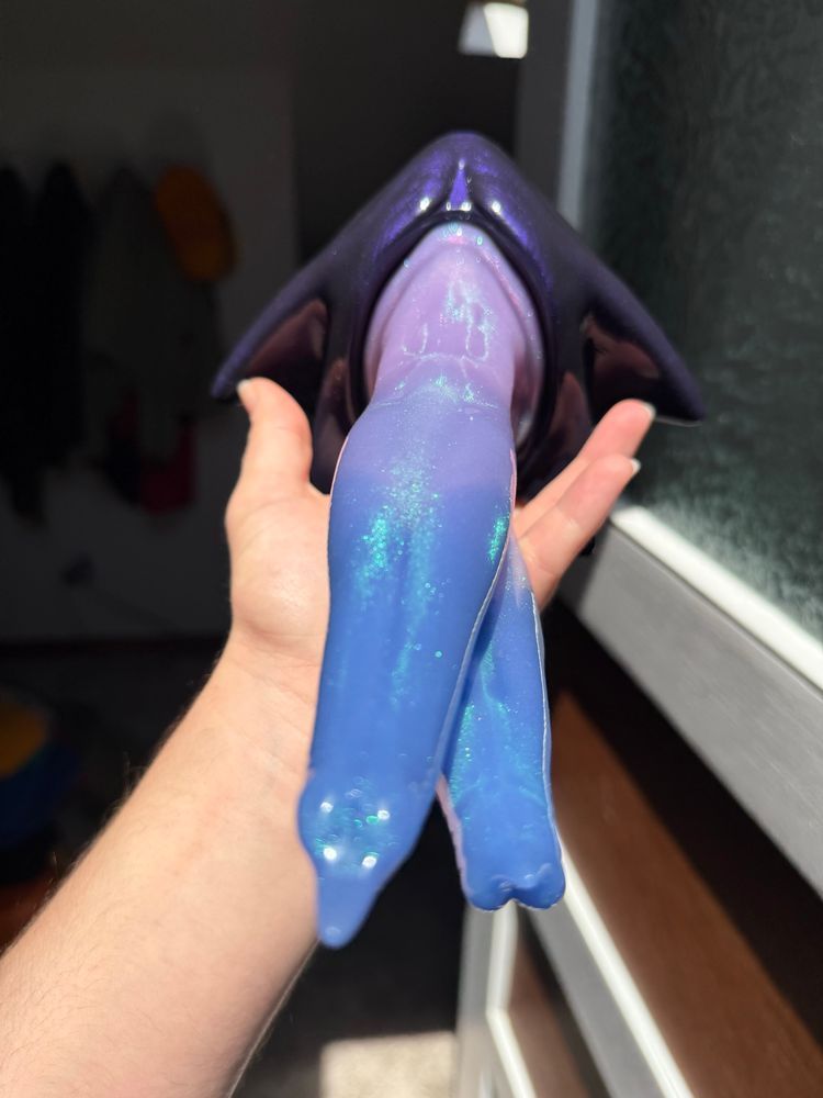 a double shafted dildo in purple and blue, with a deep purple base. its resting in my hand, with the tips facing toward the camera