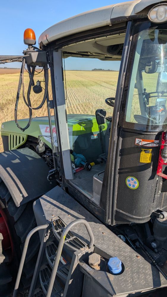 Claas Xerion 4500 tractor missing its glass door. I'm parked in a canola field on the stubble. 