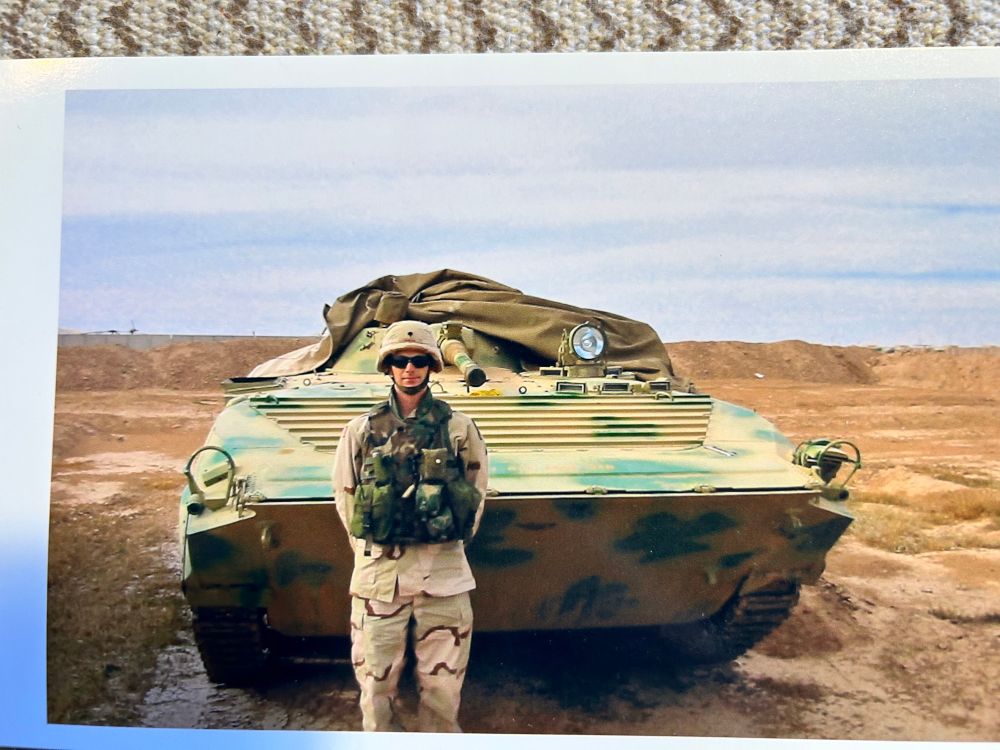 Picture of me in Iraq in desert uniform next to an Iraqi army tracked vehicle. 