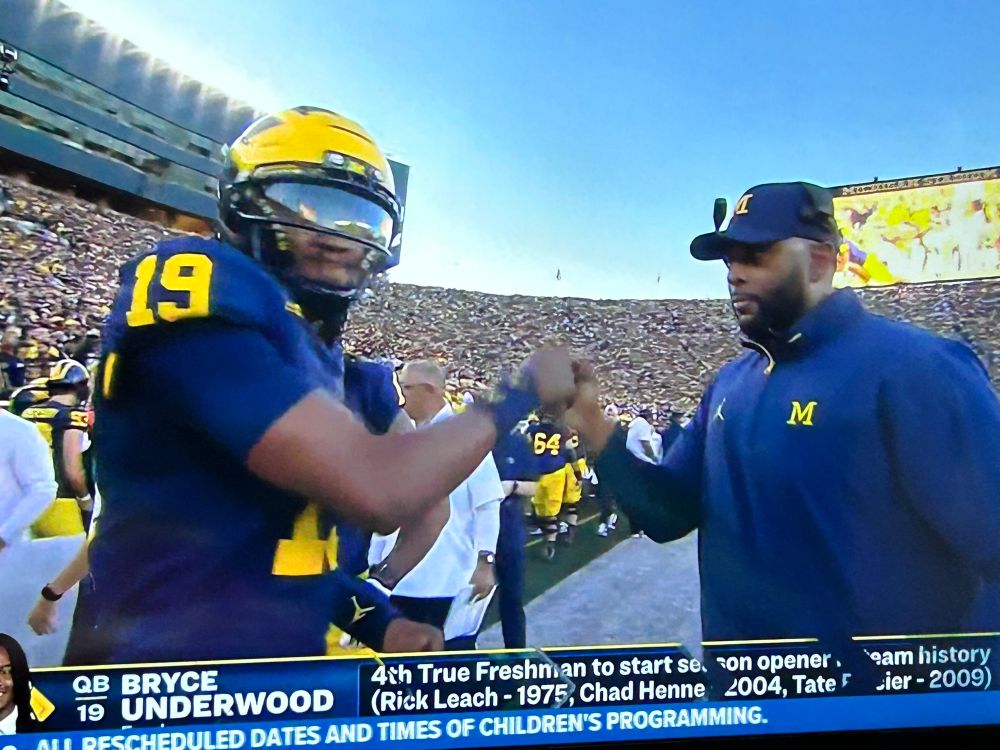 Still from my tv of the Michigan head coach fist bumping the team’s five star new freshman QB. 