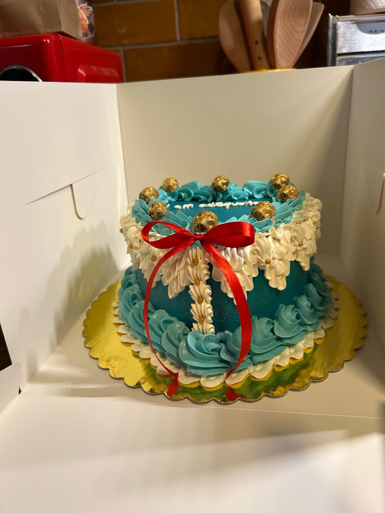 Another angle of the cake, featuring a red ribbon and gold buttons