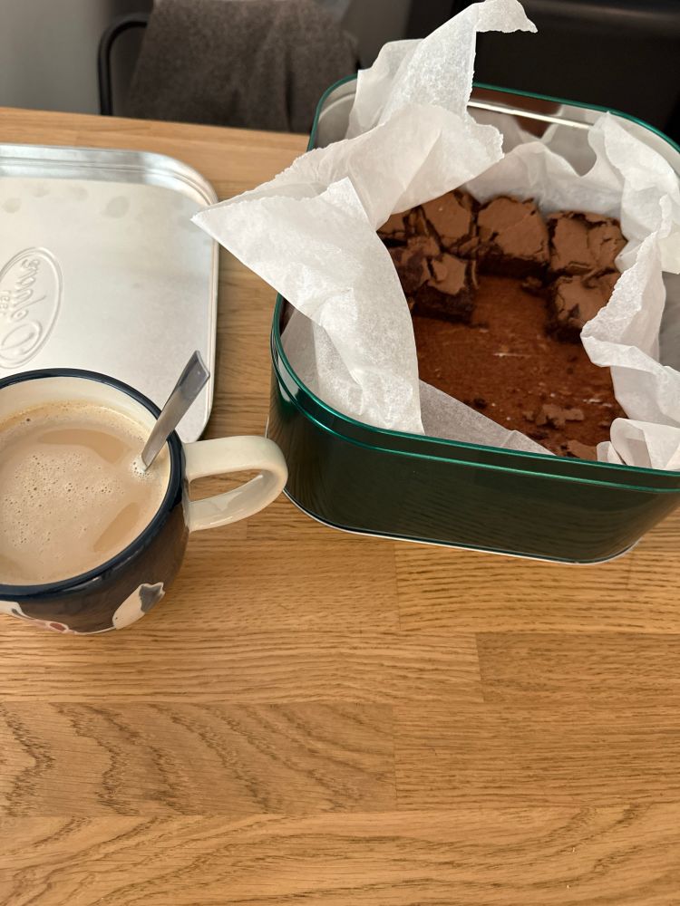 Image d’un gâteau au chocolat fait maison déjà à moitié absent, et d’une tasse de café au lait pleine