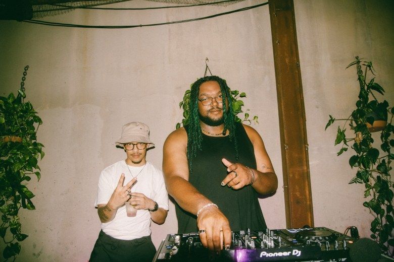Two DJs pose for the camera
