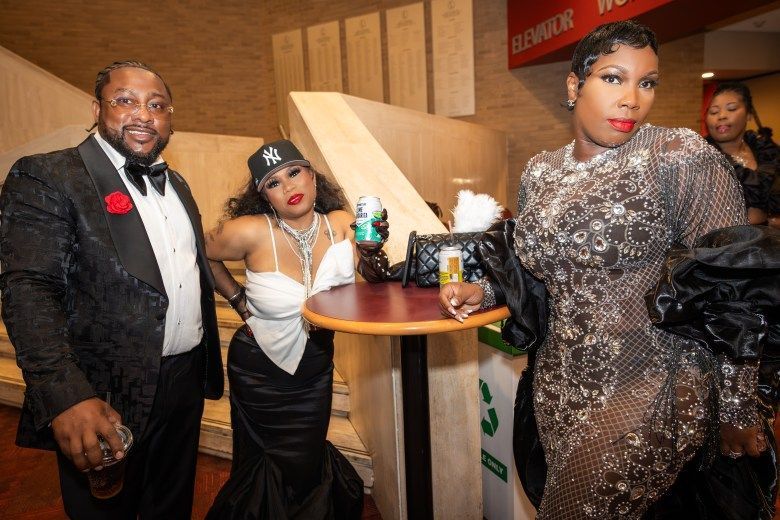 Three well-dressed people pose for the camera
