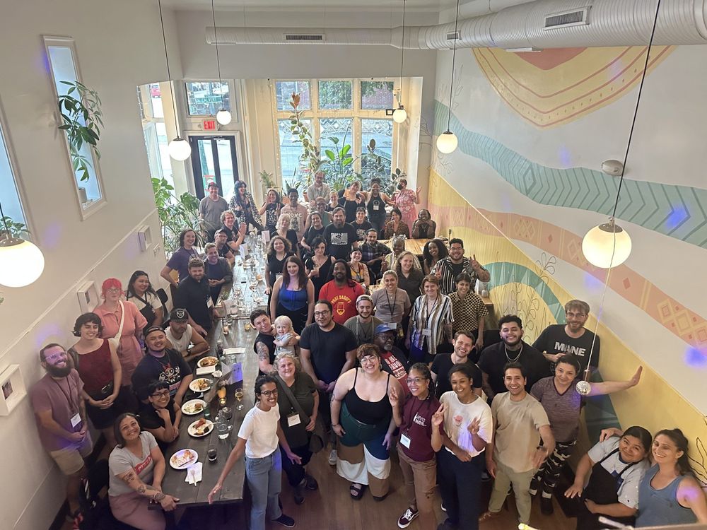 People gathered at Mera Kitchen Collective, a restaurant, smile for the camera.