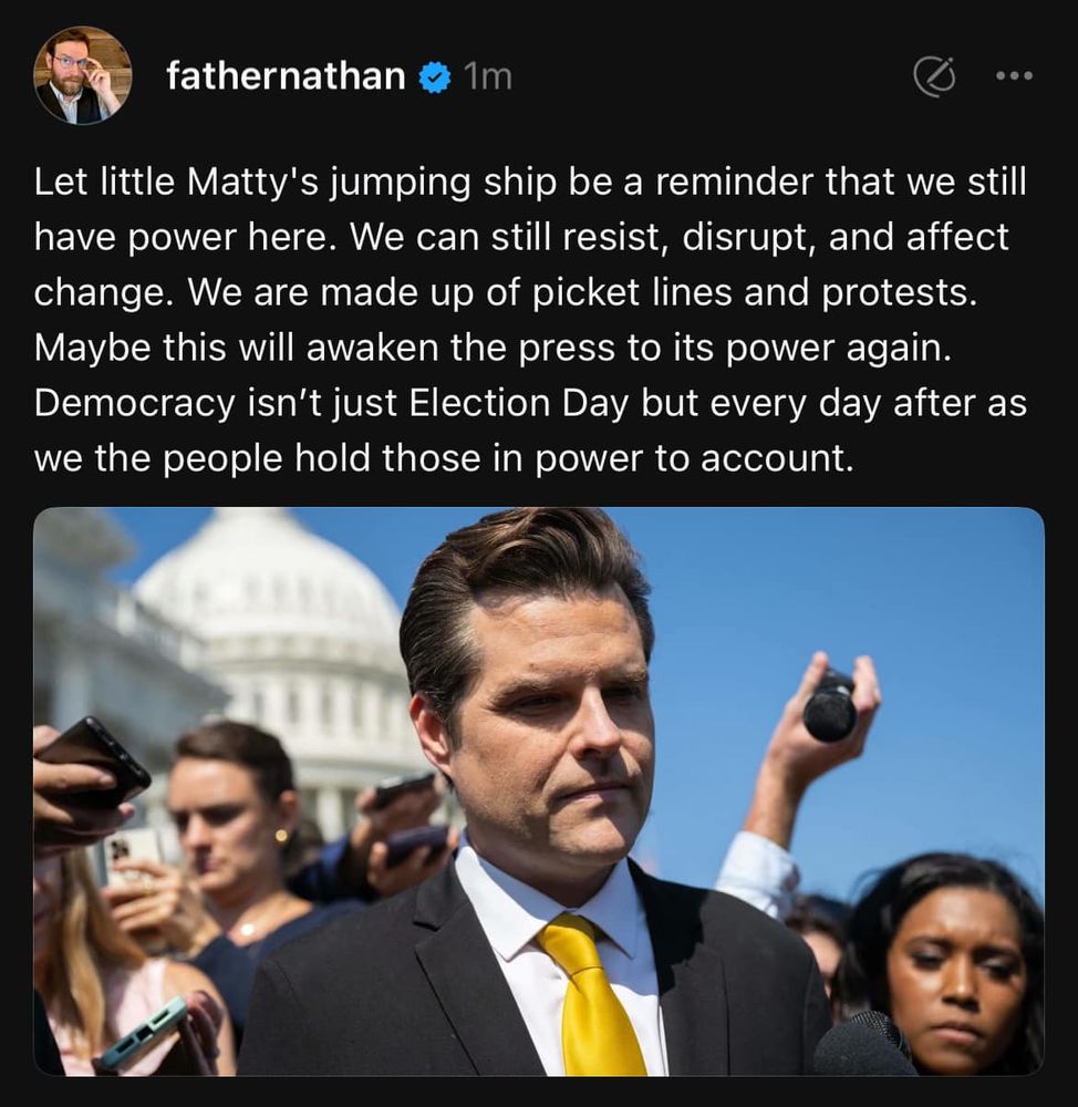 A tweet from 'fathernathan' posted 1m ago, with a profile picture showing a bearded man with glasses. The tweet discusses democratic power and protest, referencing 'little Matty's jumping ship.' Below is an image of Matt Gaetz in a dark suit and yellow tie standing outside the U.S. Capitol building, with people holding phones in the background. The tweet text emphasizes that democracy extends beyond Election Day to everyday accountability of those in power.