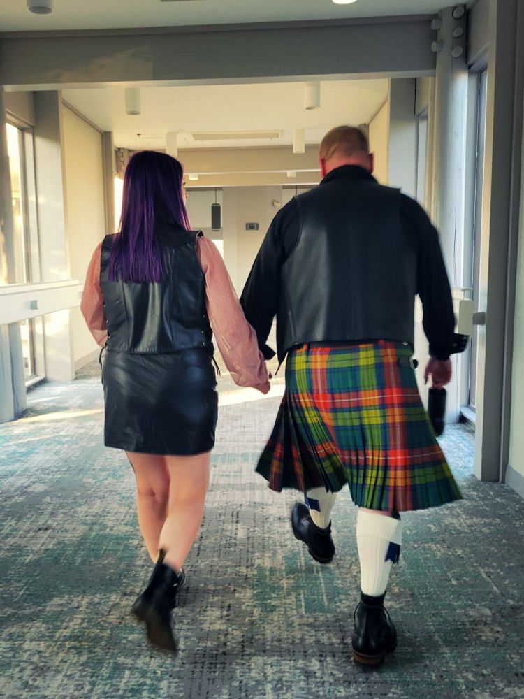 Sous-sir and darc_light walking down a hallway in their Leather best, ready for the NWLC contest finale. 