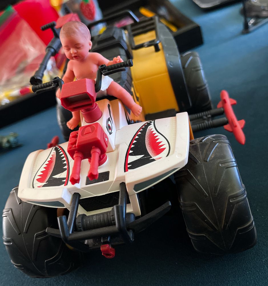 A baby sitting on the GI Joe Classified Tiger Force AtV.
