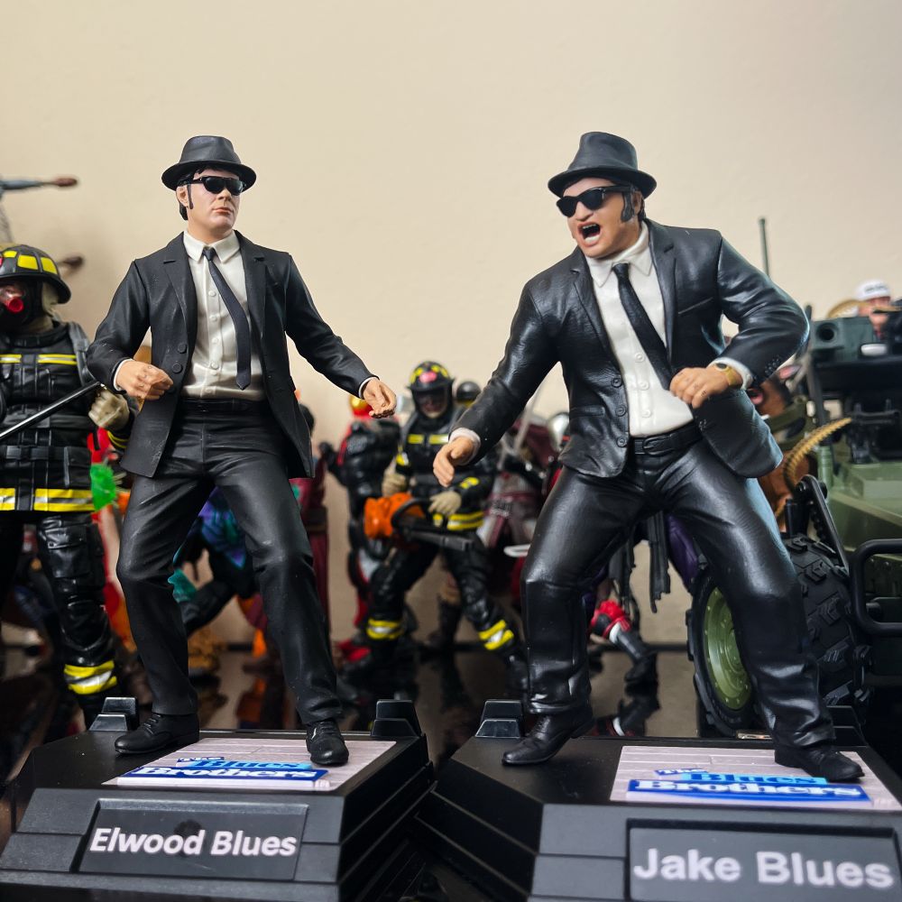 Mini statues of Jack and Elwood, The Blues Brothers. They are two guys in black suits, fedoras, glasses and ties dancing. One is singing.