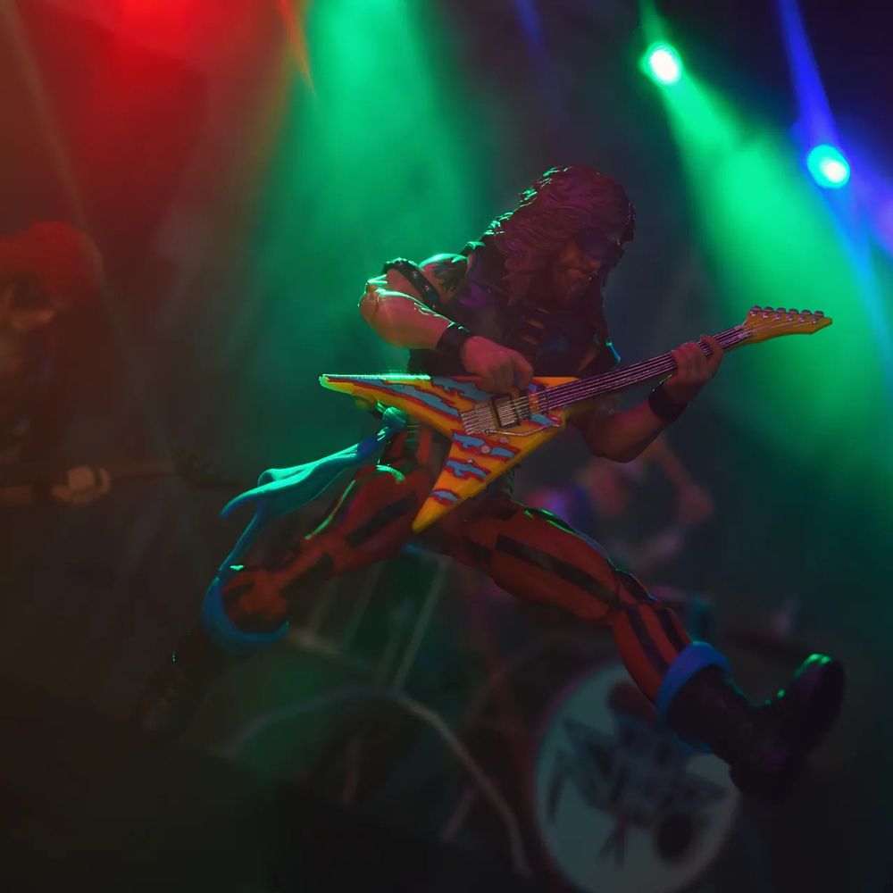 Dreadnok Ripper in glam rock disguise jumping through the air playing guitar.