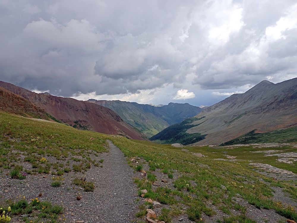 A view of a bare, dark red mountain and a bare, light brown mountain forming a valley, taken on Rolling Mountain