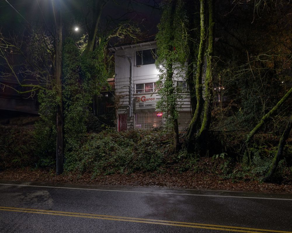 The back of a strip club called "G Spot" on a rainy night.