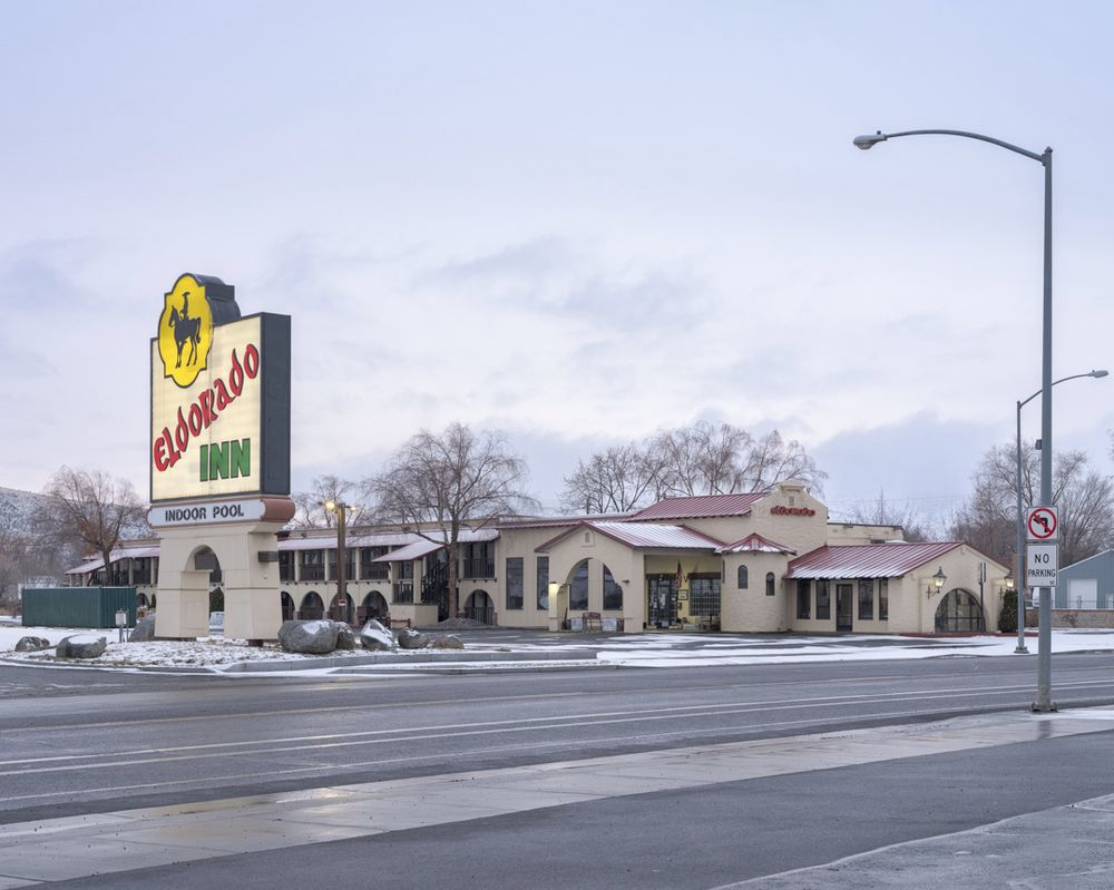 Eldorado Inn, a western themed hotel, seen on a cold, cloudy day. There is snow on the ground except on pavement, where it's melted.