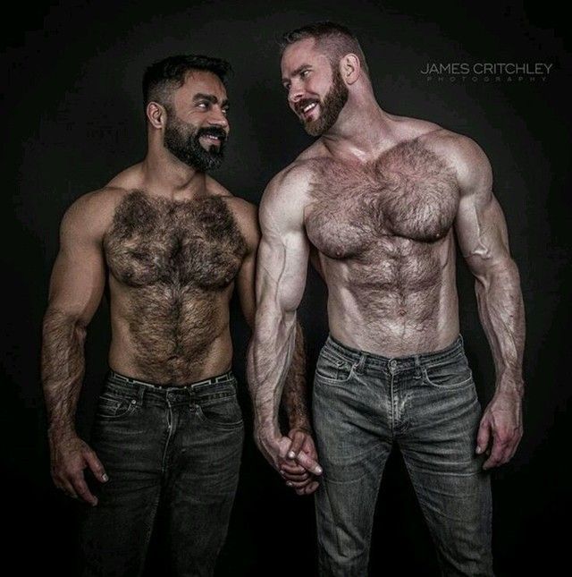 Two sexy hairy men, shirtless and looking at each other while holding one and. Their connexion is undeniable and their manliness too.