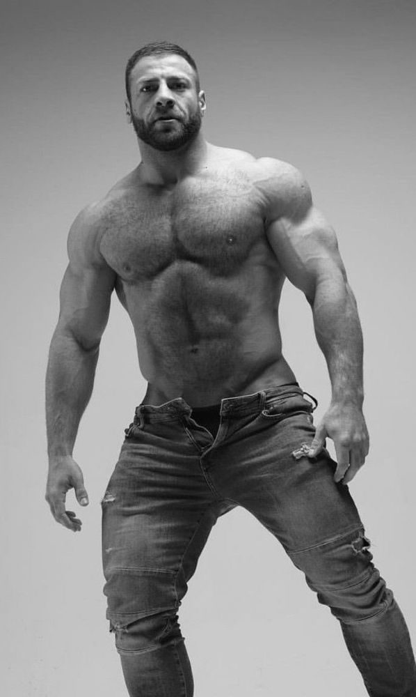 Hunky hairy man, wearing only denim jeans, looking confuse at the camera