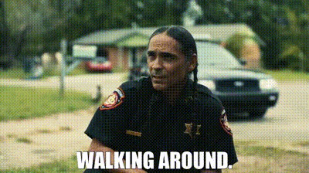 a native american police officer is walking around in a field .