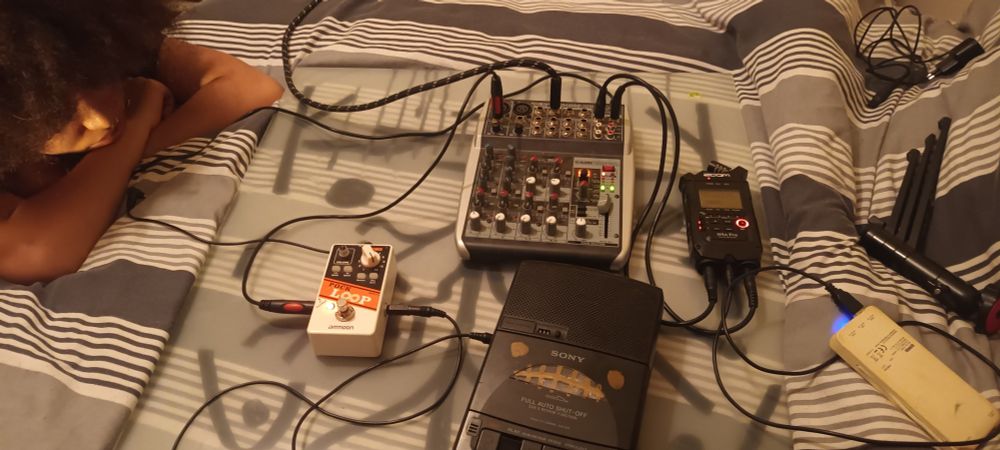 A tape deck feeding into a looper pedal, which feeds into a mixer, a recorder is also plugged into the mixer