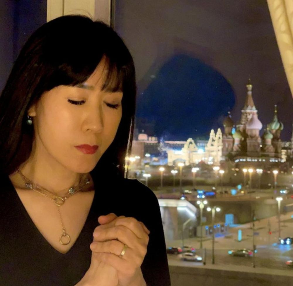 So-yeon Schröder-Kim betend. Im Hintergrund ist Moskau zu sehen.
