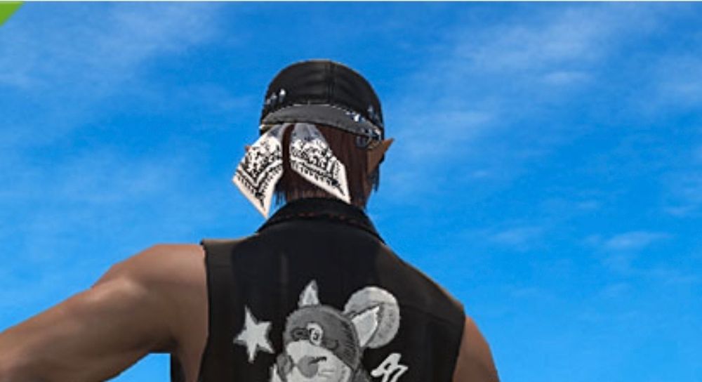 A backwards baseball cap with a bandana under it. 