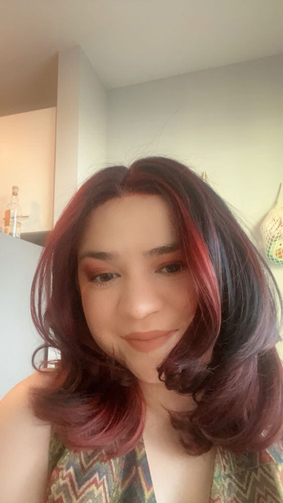 Selfie of a person with red and black hair smiling into camera 