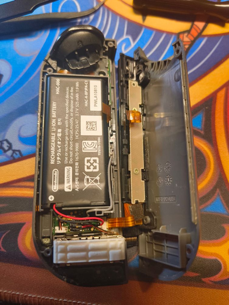 JoyCon abierto con el cable de los leds partido