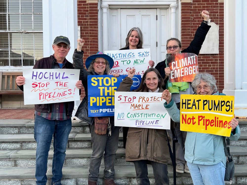 6 people stand together holding signs “Hochul: stop the pipelines”