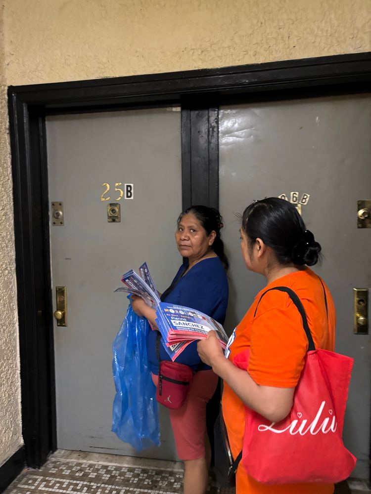 2 NYCC members get ready to ring a doorbell inside an apartment building 